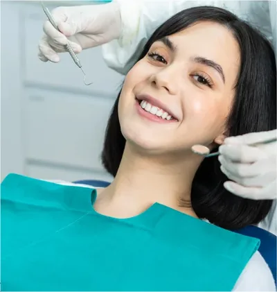 A young woman smiles as a mirror is brought to her mouth