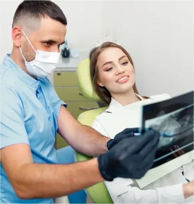 A dentist and a patient look together at a dental X-ray
